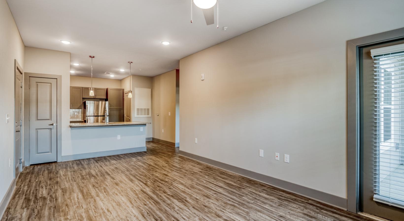 Settle into comfort at Ascent Athens a room with a ceiling fan and a wood floor