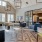 a large living room with a large glass wall and a large dining table