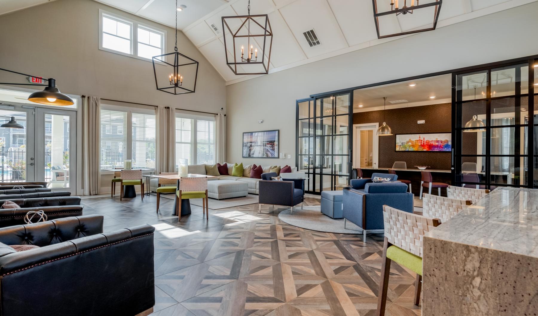 Settle into comfort at Ascent Athens a large living room with a large glass wall and a large dining table