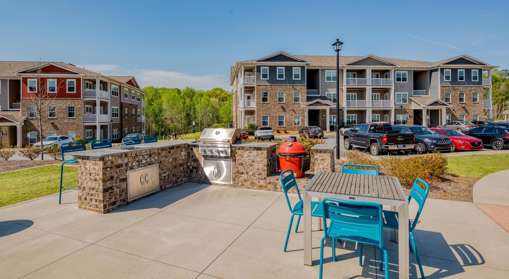 Settle into comfort at Ascent Athens a patio with chairs and tables and cars in the background